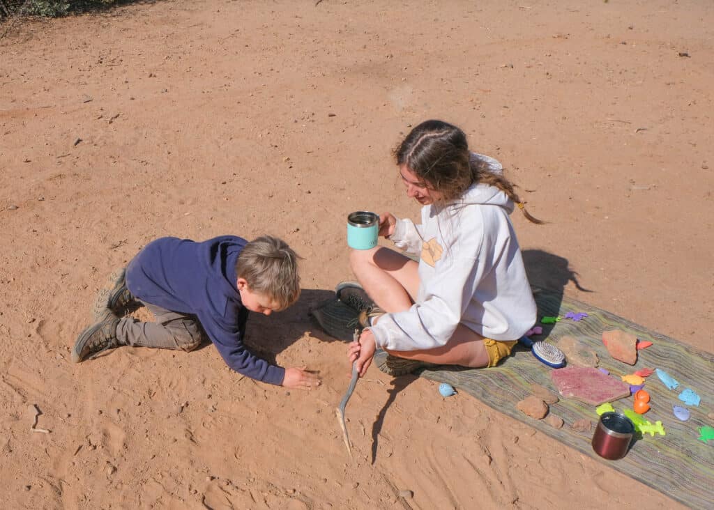 sitting on sand free mat playing with child