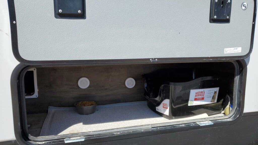 litter box set up in storage compartment of camper