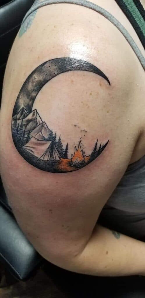moon mountains tent and campfire tattoo on arm