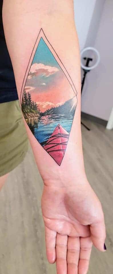 realistic color kayaking tatooo with frame forearm