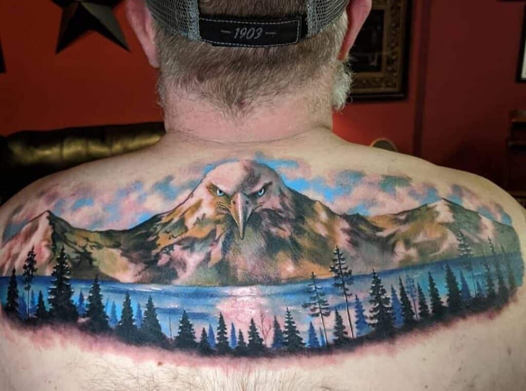 full color mountain and lake scene with eagle in mountains back shoulders tattoo men