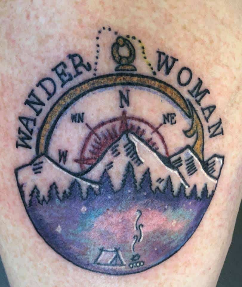 womens camping tattoo with compas and mountains