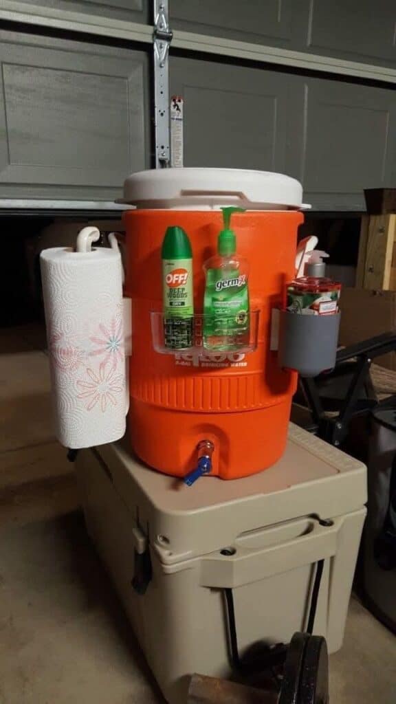 water cooler with sanitary items attached to it for camping