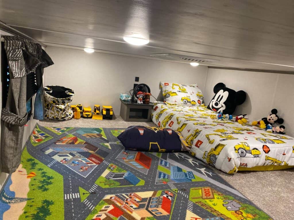 kids room in 5th wheel attic with cute car rug