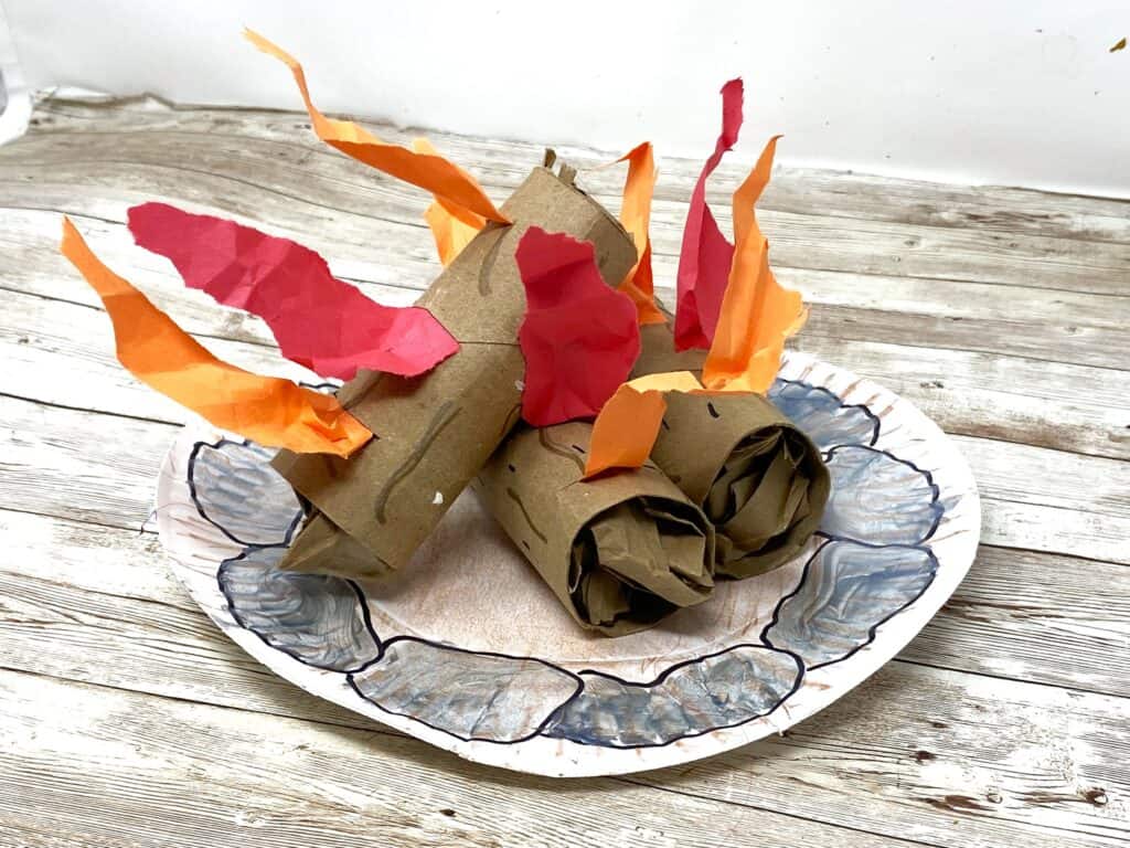 stacking toilet paper logs onto campfire ring plate