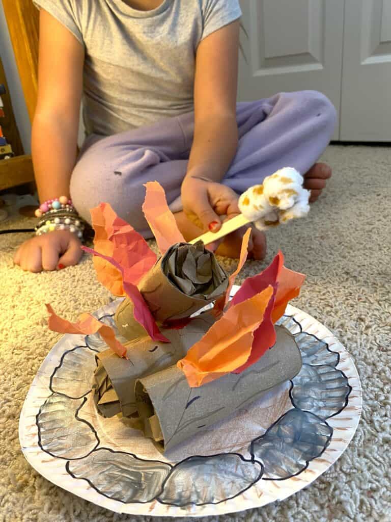 child using pretend play campfire set with smore and campfire made from toilet paper rolls