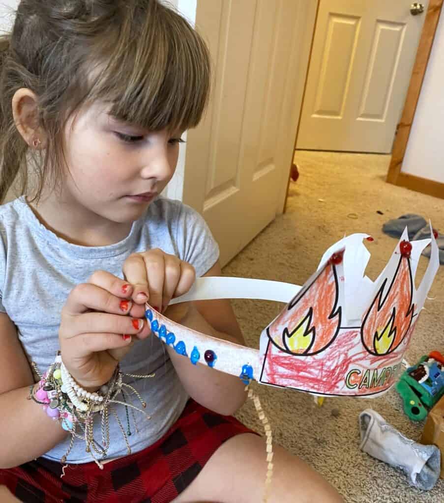child crafting a camping themed hat