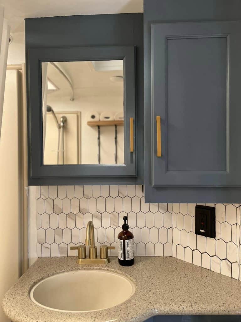 white tile backsplash and blue cabinet in bathroom or rv