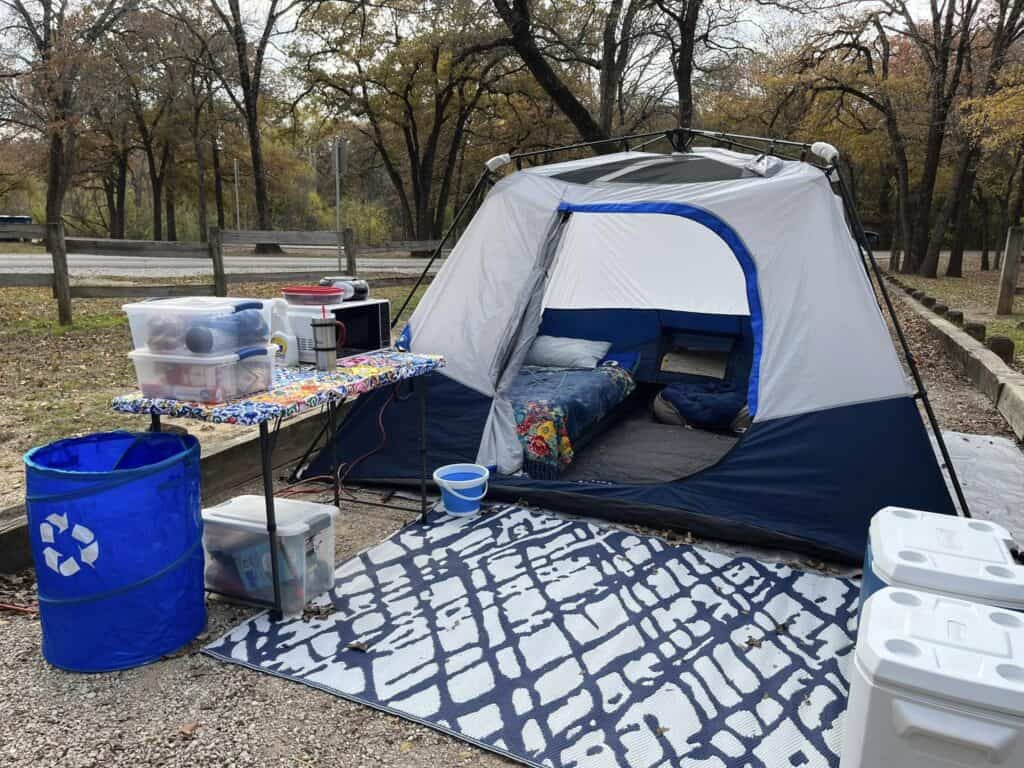 well organized tent campsite with things in clear bins