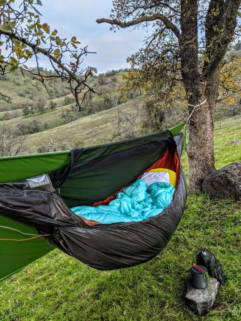 pretty hamock in between two trees overlooking a hill side