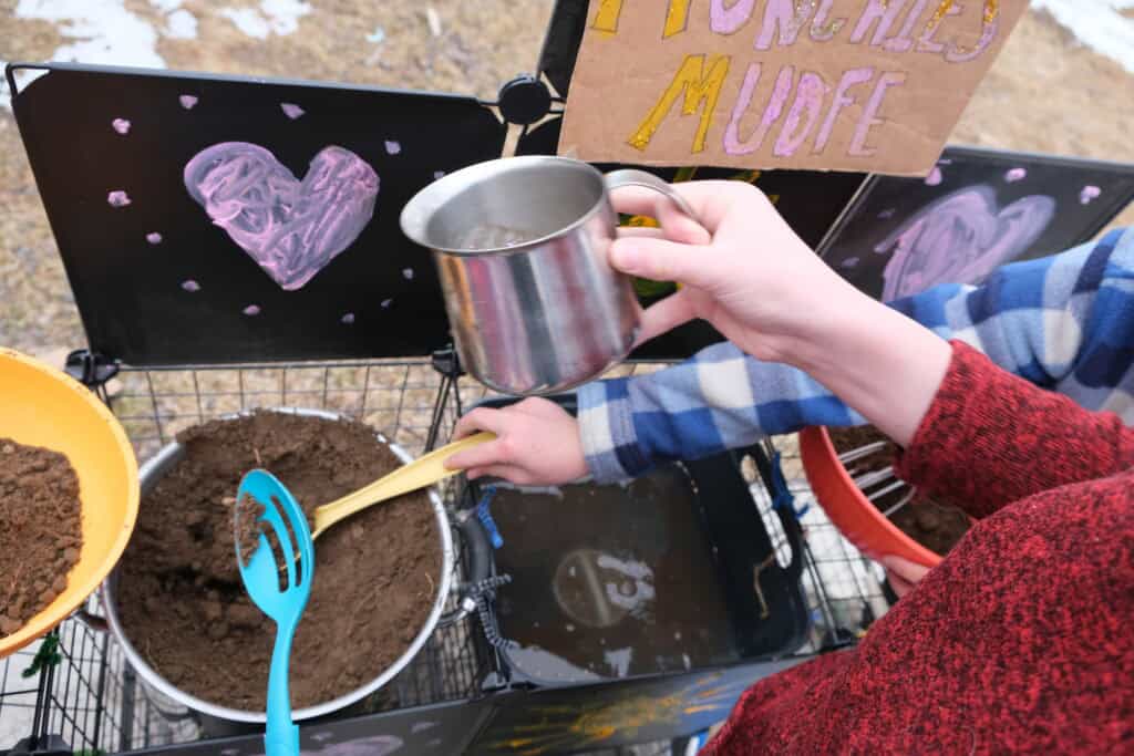 ideas for what to stock in mud kitchen pouring cup, mixing bowls, slotted spoons, camp sink that drains